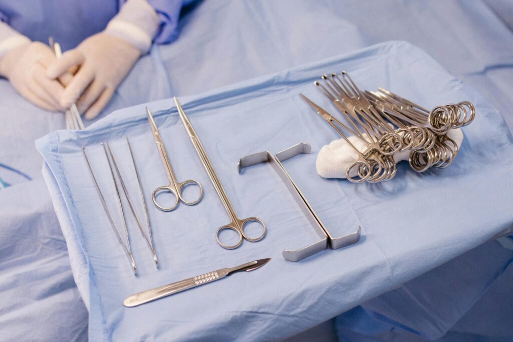 A set of surgical instruments carefully arranged on a blue drape during an operation.