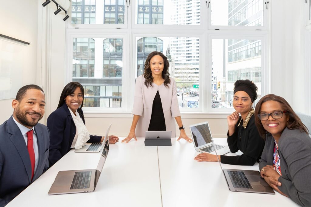 Multicultural team collaborating in boardroom with laptops, showcasing teamwork and diversity.