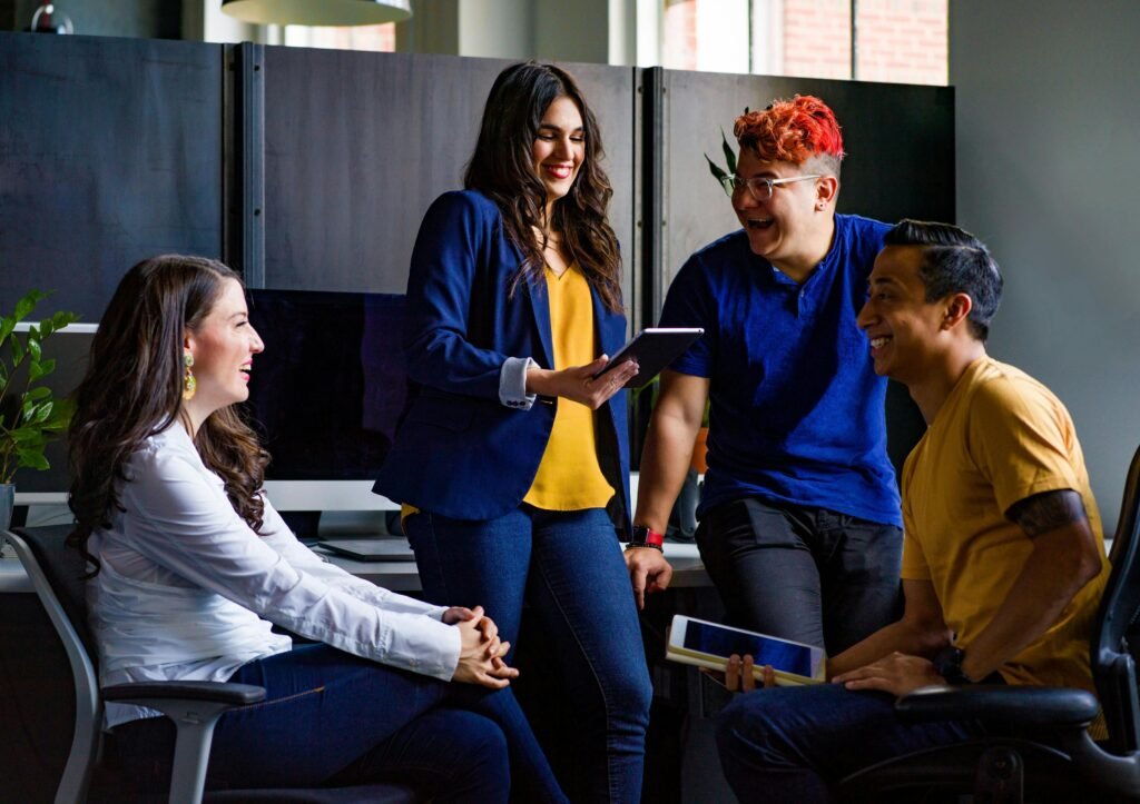 A diverse group of coworkers engaging in a lively discussion in a stylish office environment.