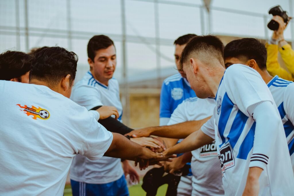 Young male soccer team in a huddle, showing unity and teamwork on the field.