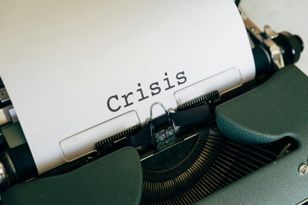 Close-up of a vintage typewriter with the word 'Crisis' typed on paper.